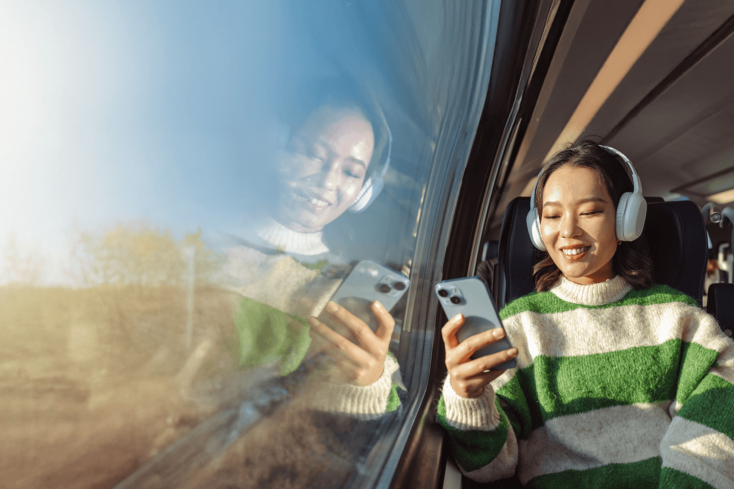 Traveller checking her phone on a train