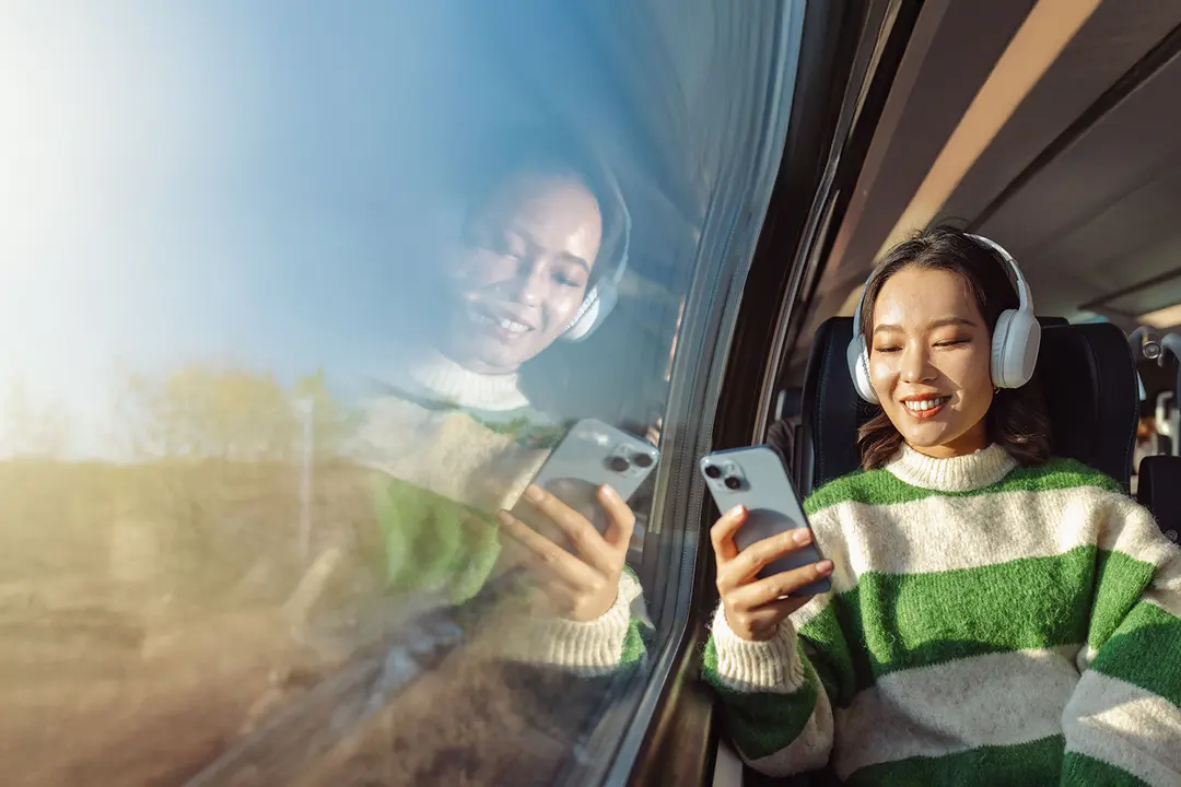 A creator using her phone while travelling by train