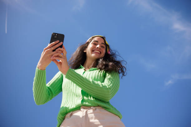 Traveller smiling while using her phone outside